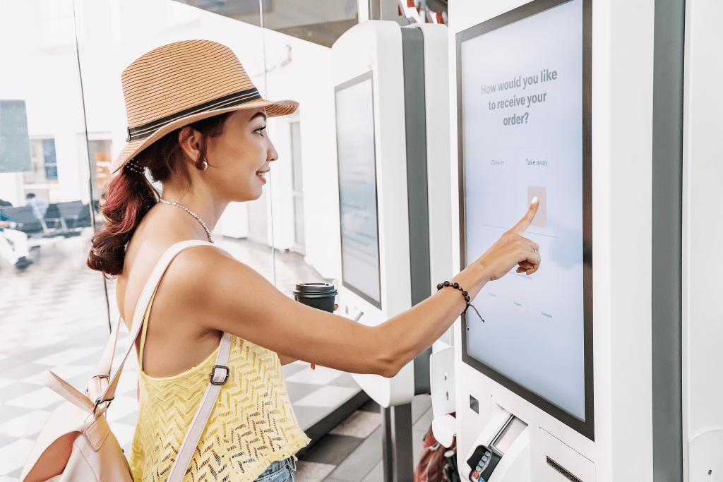 kiosk-self-checkout Frau kauft an Kassenautomat ein
